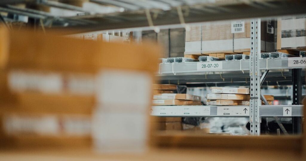 Warehouse metrics dashboard beside stacked boxes and a scanner, showing the focus keyword as an early warning signal for fulfillment problems