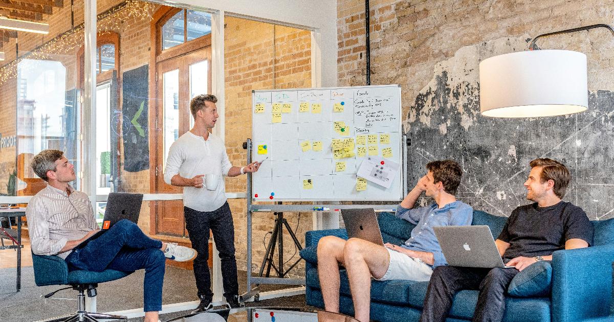 A product team discussing test results on a whiteboard, using psychological safety to surface doubts and improve the product decision