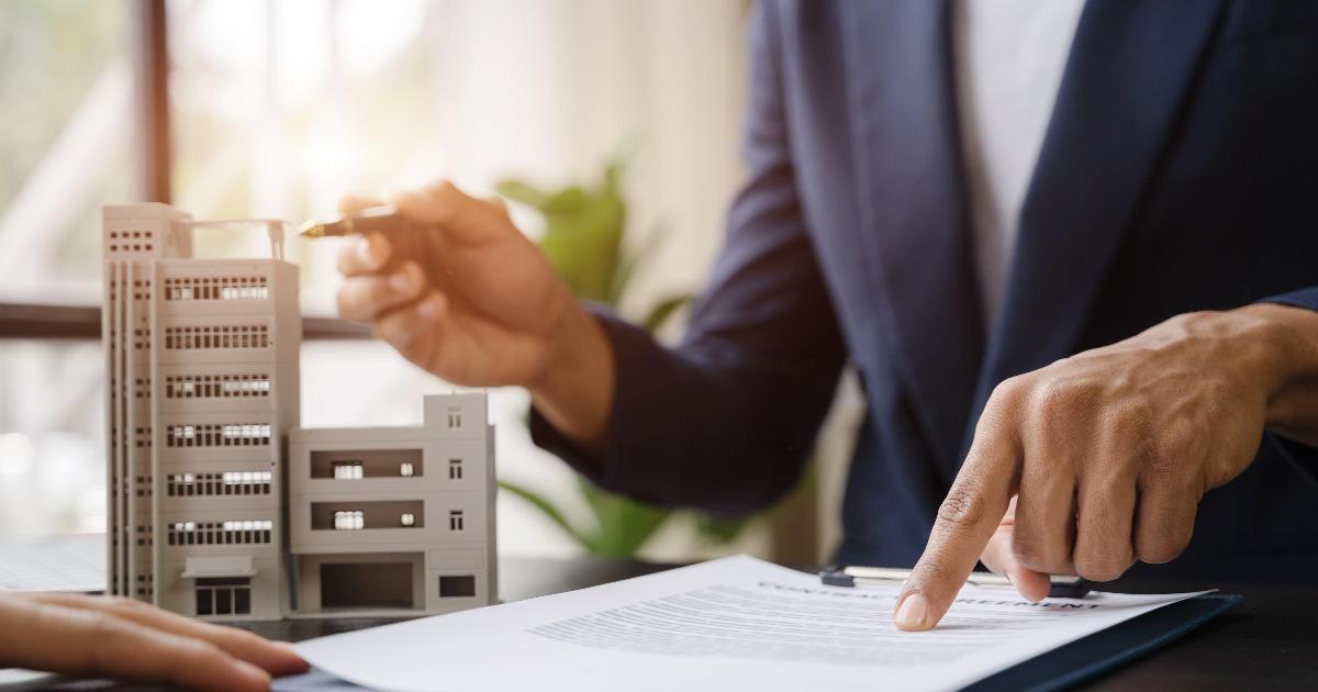 A real estate agent reviewing documents with a homebuyer, illustrating a real estate unbundling market signal