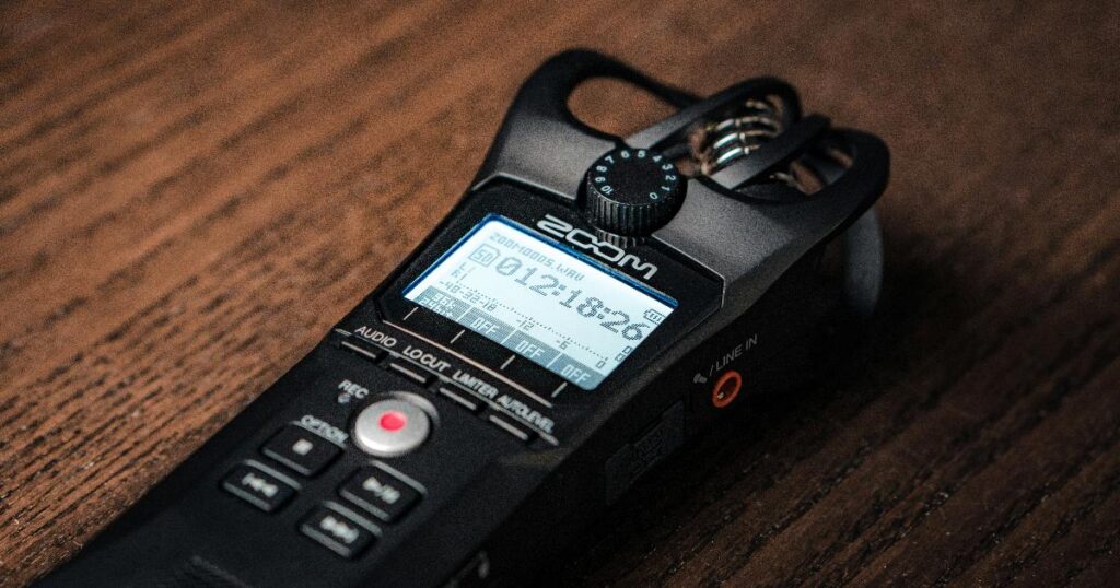 An AI voice recorder clipped to a phone, illustrating demand validation signals from a real hardware purchase