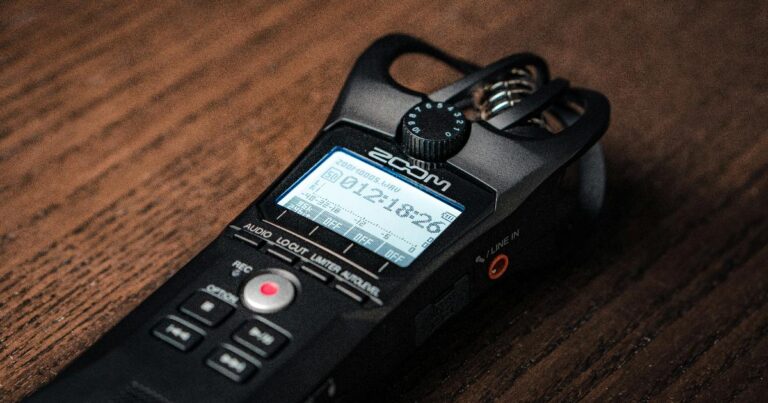 An AI voice recorder clipped to a phone, illustrating demand validation signals from a real hardware purchase