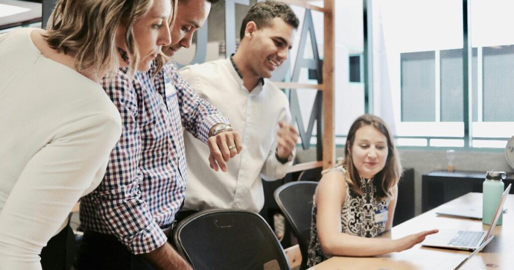 A small business team reviewing growth pain signals on a dashboard and notebook, using the data to spot early warning signs