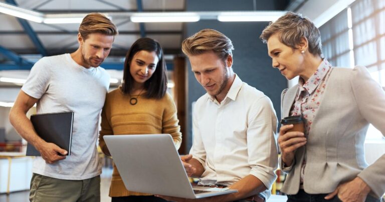 A startup team reviewing an interactive product demo on a laptop, using the demo as a demand experiment to study user behavior