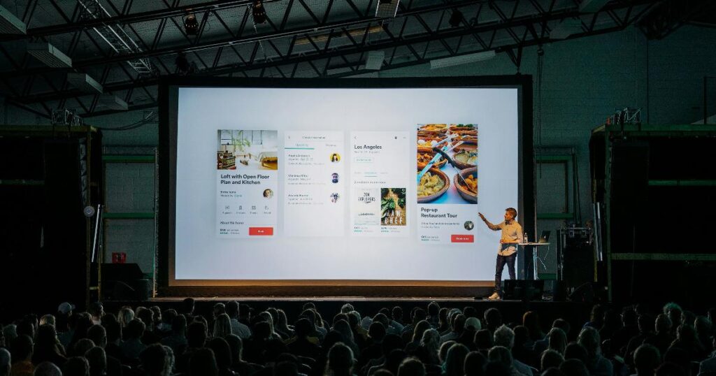 Founders presenting a startup pitch as a business hypothesis in front of a small audience