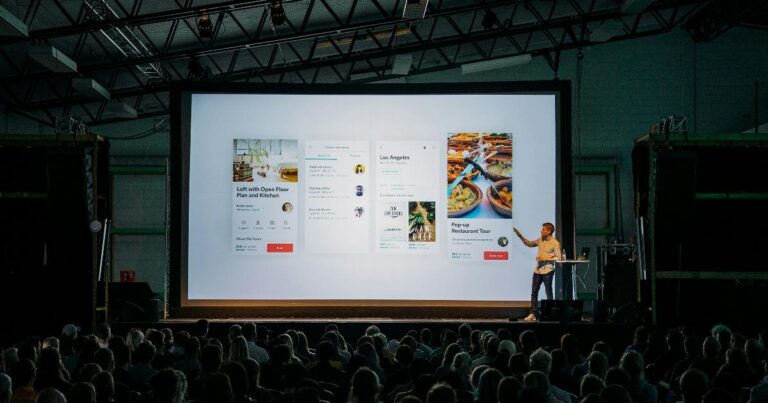 Founders presenting a startup pitch as a business hypothesis in front of a small audience